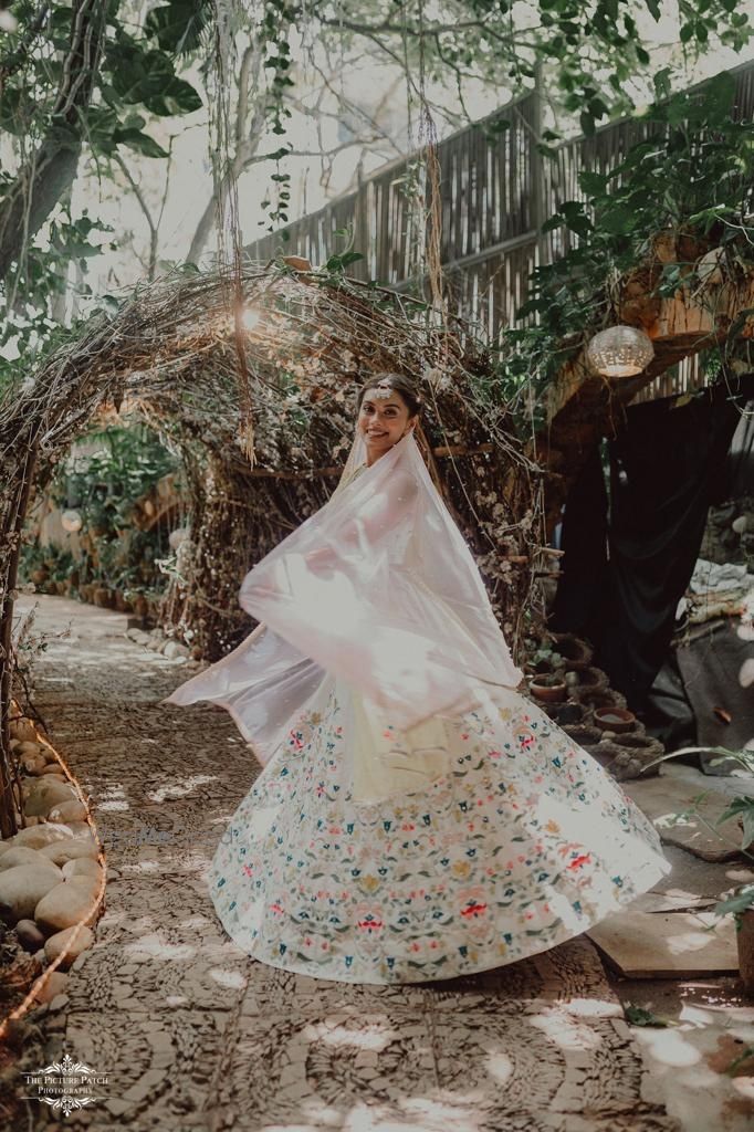 Photo of Bride twirling around in her ivory lehenga.