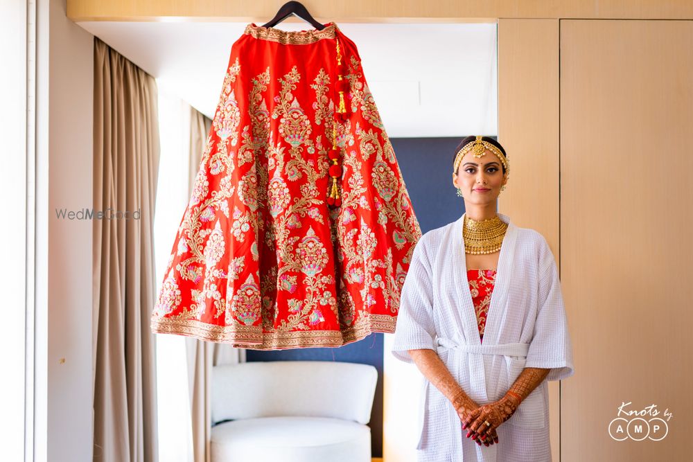 Photo of Bride in robe shot with lehenga on hanger