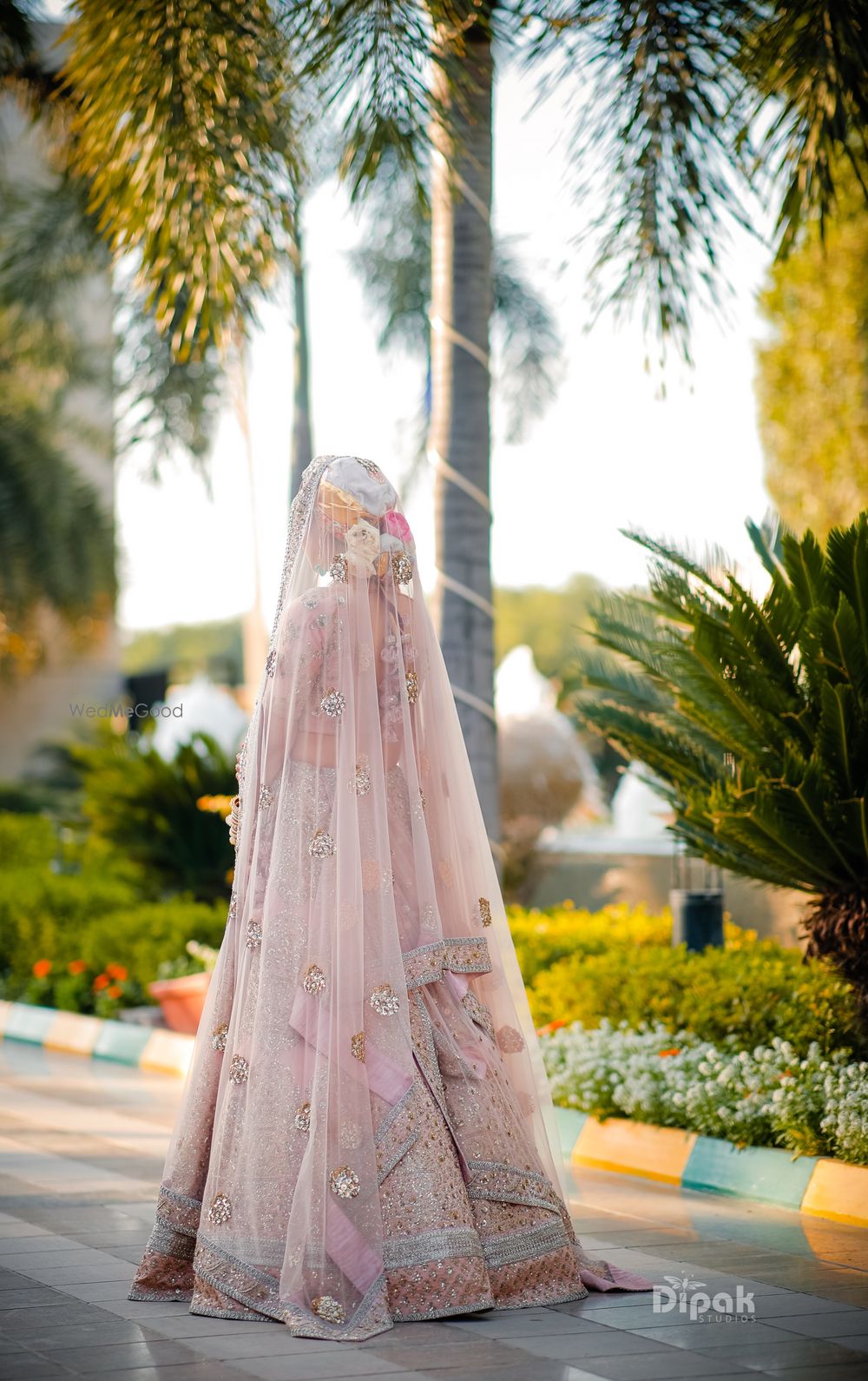 Photo of Bridal back shot in pastel lehenga and bun