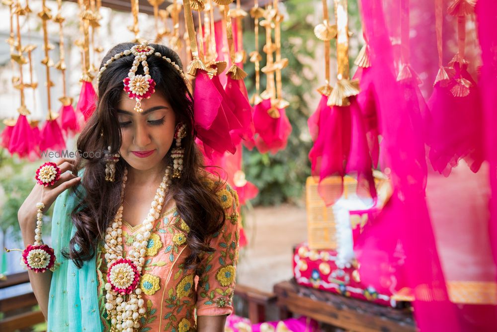 Photo of A bride in white and pink floral jewellery for her mehndi