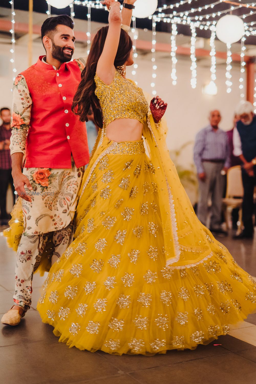 Photo of Dancing couple shot on sangeet with mustard yellow lehenga