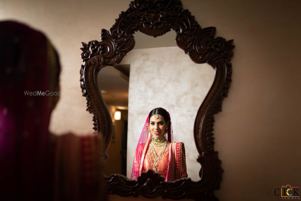 Photo of bride looking at mirror after getting ready on wedding day