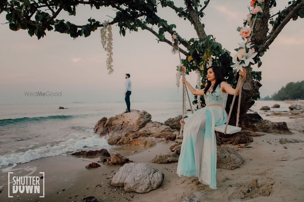 Photo of beach pre wedding or honeymoon shot with bride on swing