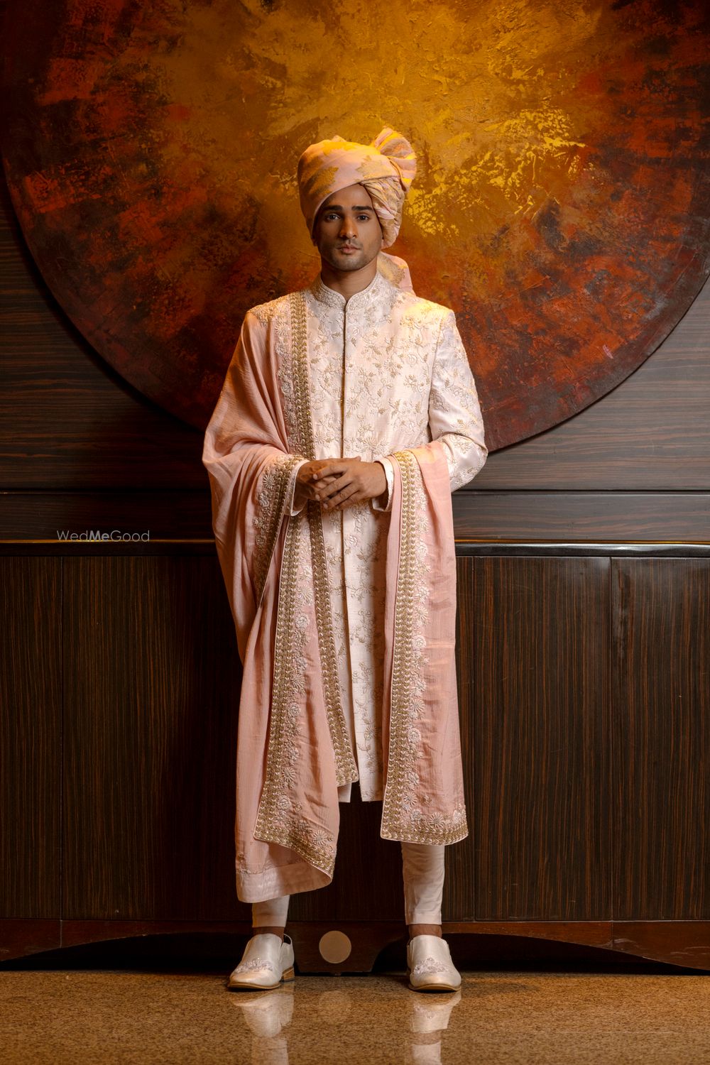 Photo of Groom in peach and cream sherwani.