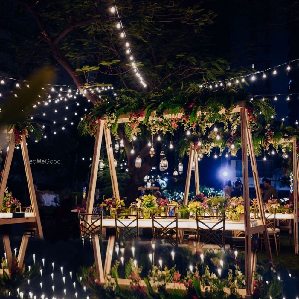 Photo of An outdoor table setting with lush greens and florals.