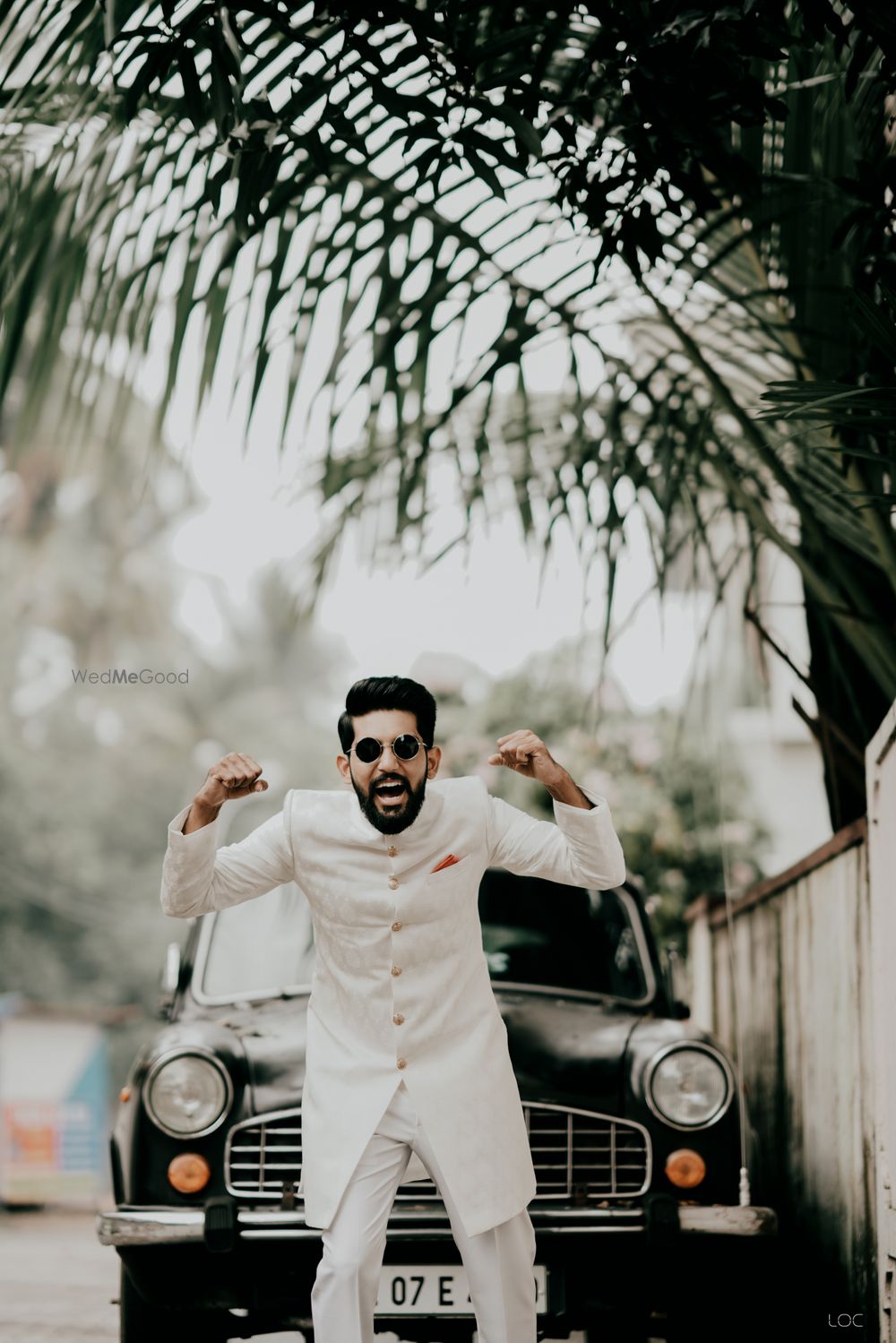 Photo of crazy groom in vintage car backdrop