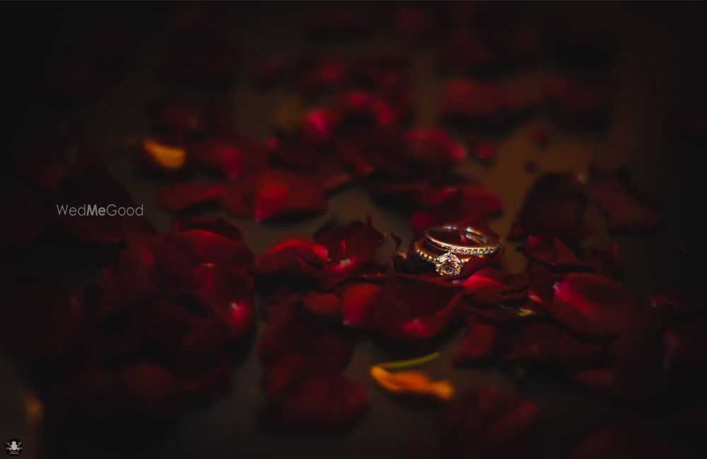 Photo of His and Her Engagement Rings with Rose Petals