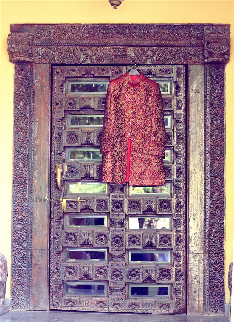 Photo of Deep Red Sherwani Hung on Royal Door