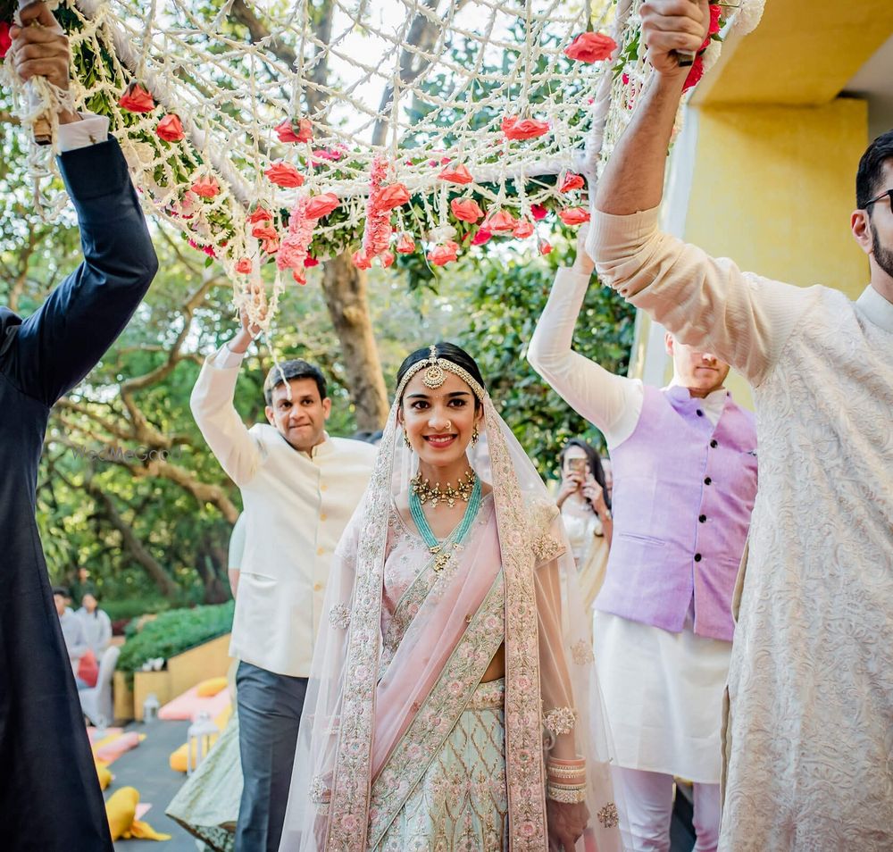 Photo of Bridal entry under a phoolon ki chaadar.