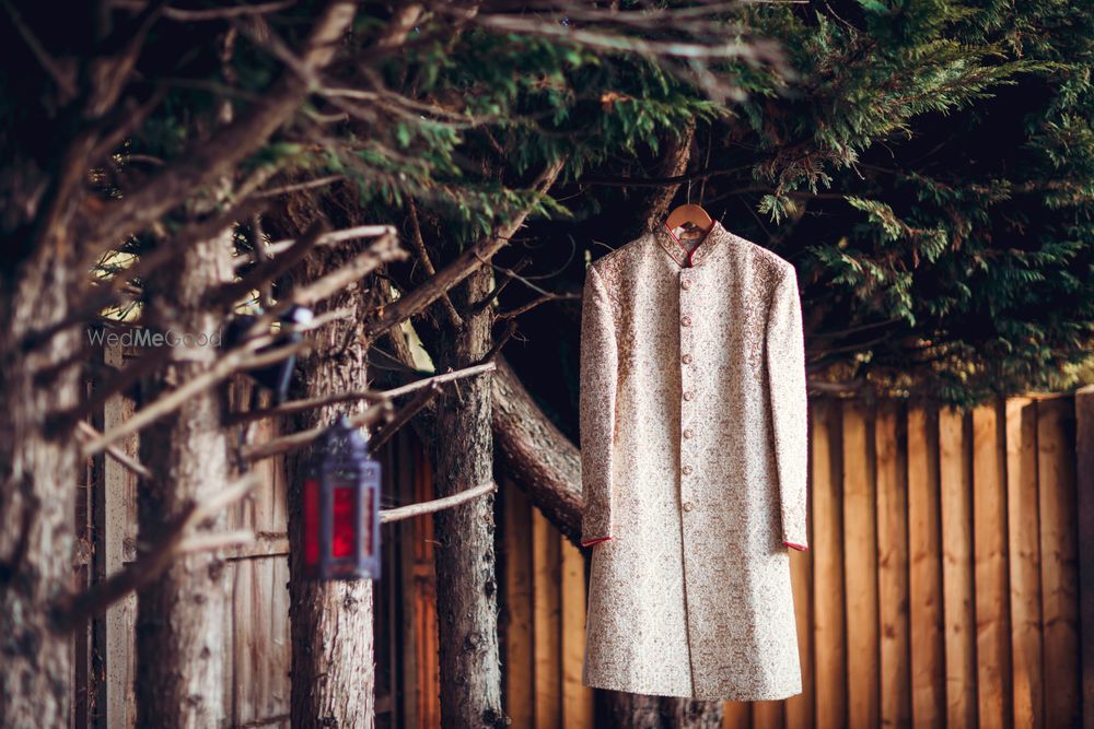 Photo of floral sherwani on hanger on a tree