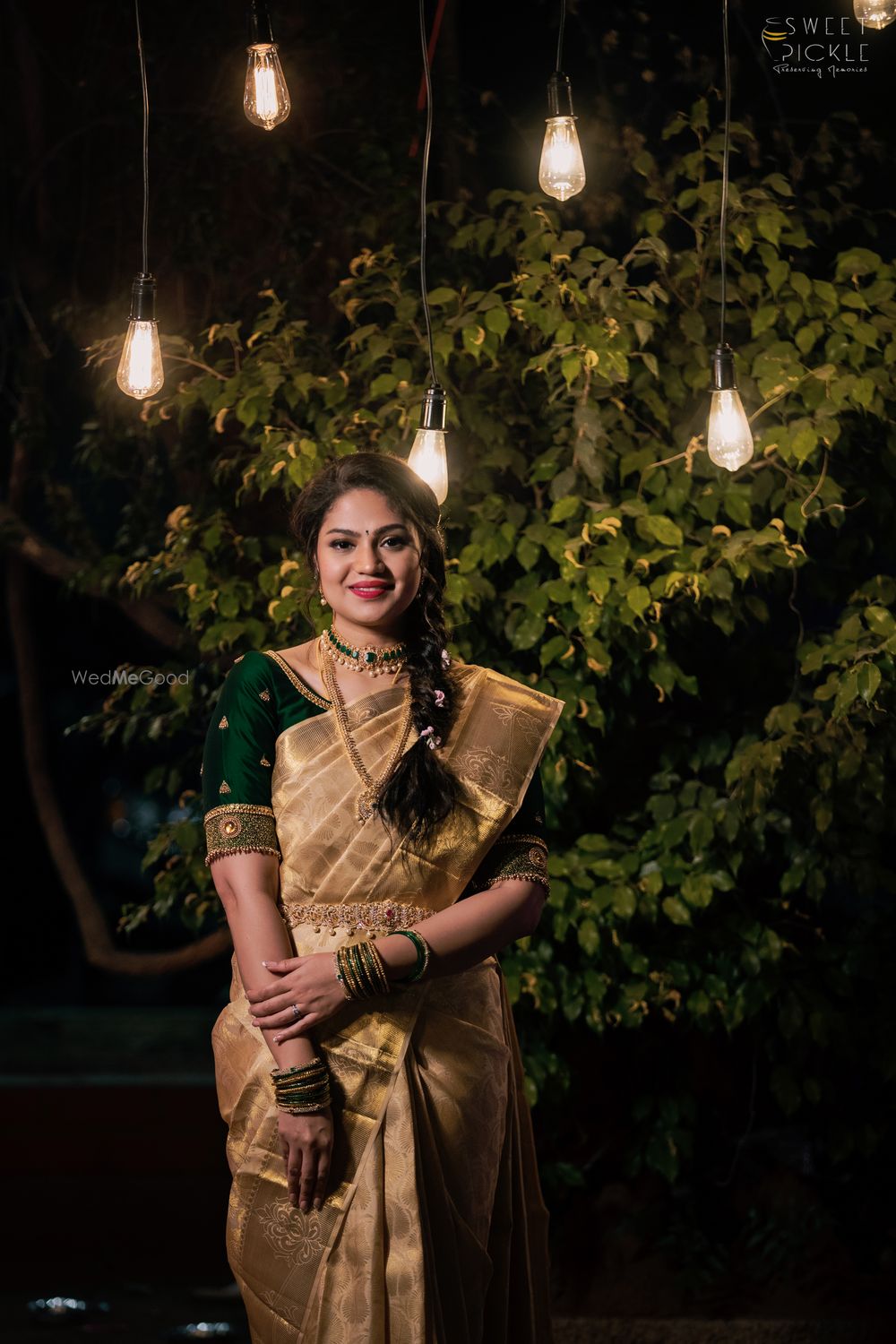 Photo of Bride wearing a gold saree with a bottle green blouse.