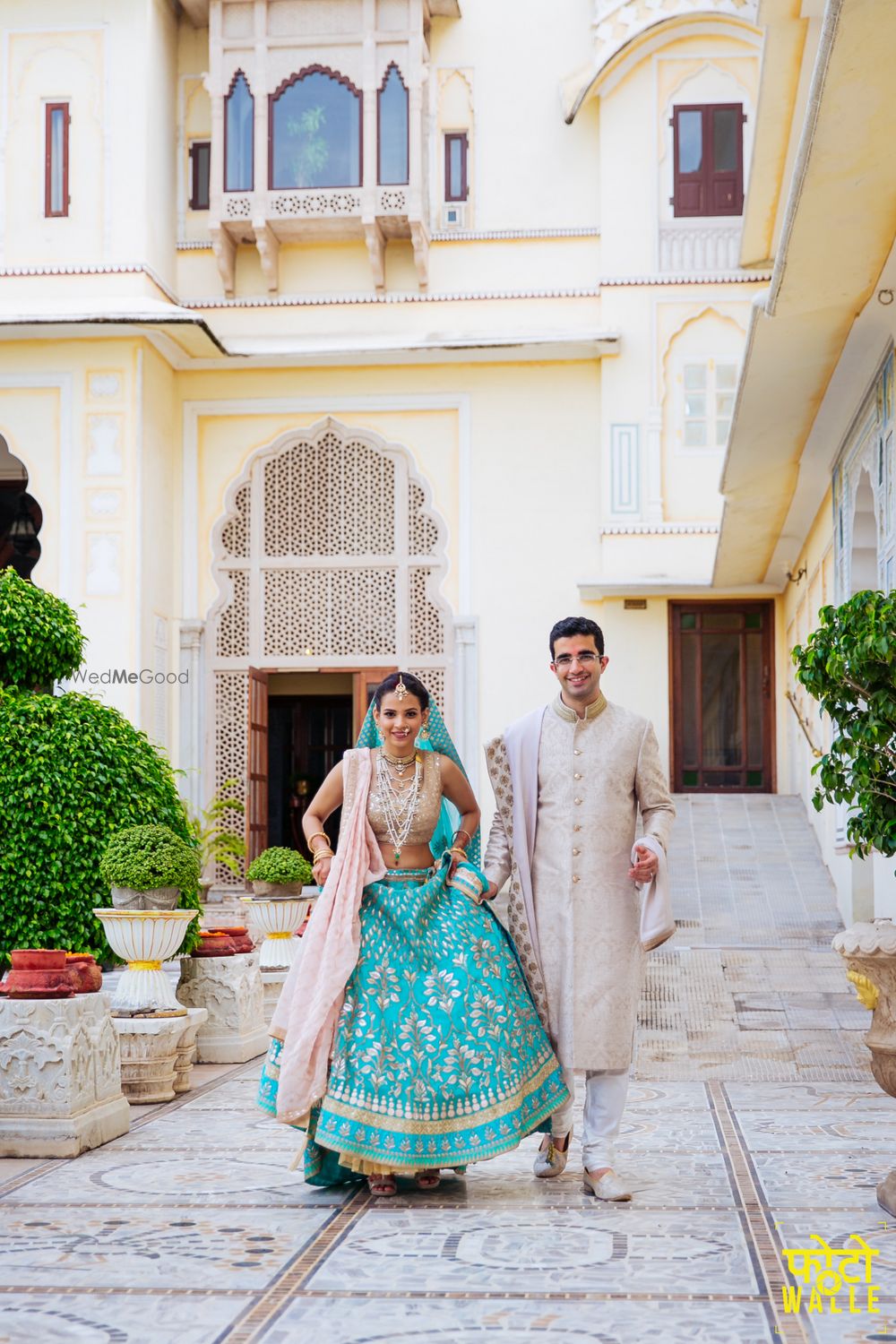 Photo of Groom with bride wearing light blue bridal lehenga