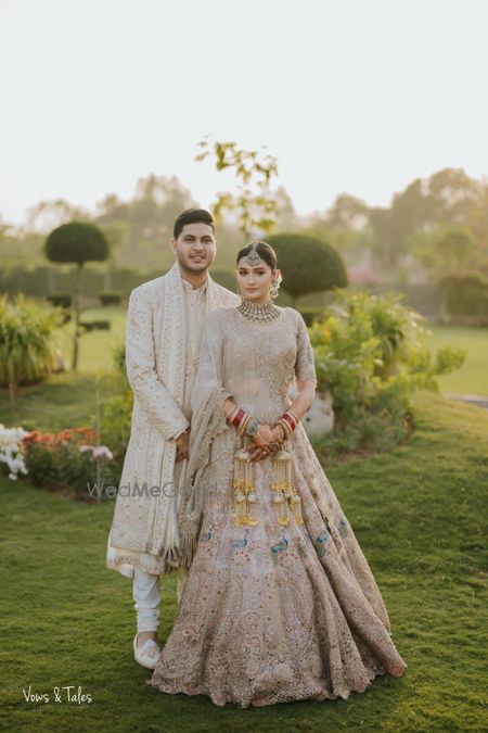 Photo of Lovely couple portrait with the bride in a pastel lehenga with peacock motifs