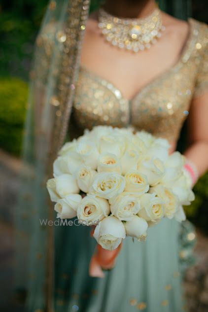 Photo of Bride in lehenga holding bouquet