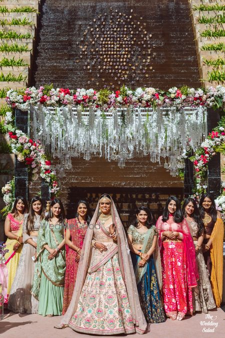 Photo of cute bride with bridesmaids shot idea against mandap