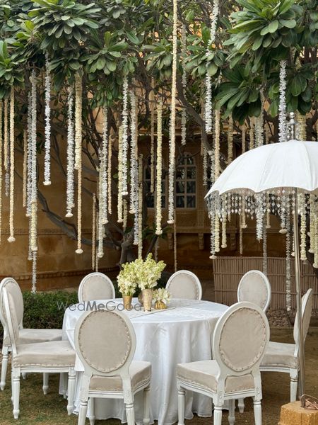 Photo of Stunning all-white decor with hanging florals and white umbrellas for an outdoor event