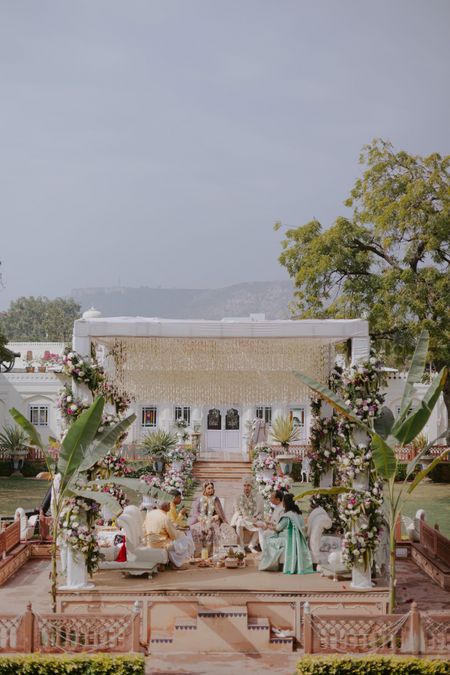 Photo of Gorgeous white and green mandap in the outdoors for the wedding day