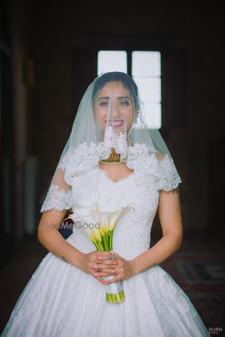 Photo of Bride with lace veil and bridal bouquet