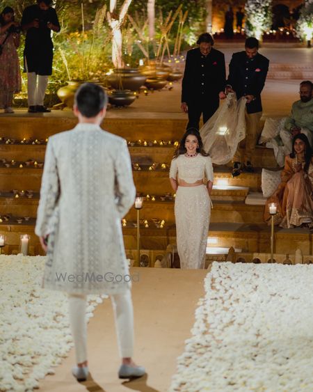 Photo of Beautiful bridal entry with bride in a ivory coloured co-ord set and ruby jewellery