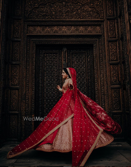 Photo of Pretty twirling shot of a bride in a red lehenga