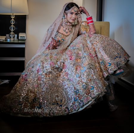 Photo of A gorgeous bridal pose shot, focusing on the details of the bridal lehenga