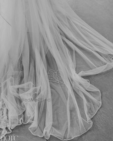 Photo of Personalized veil shot with bride and groom initials embroidered on it.