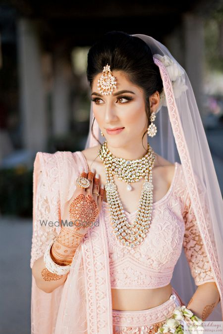 Photo of Poufy bridal bun with dupatta light pink pinned