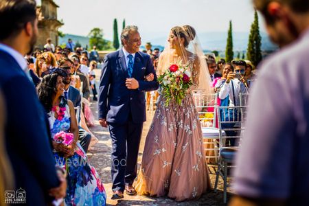 Photo of Offbeat bride in peach gown entering with her father