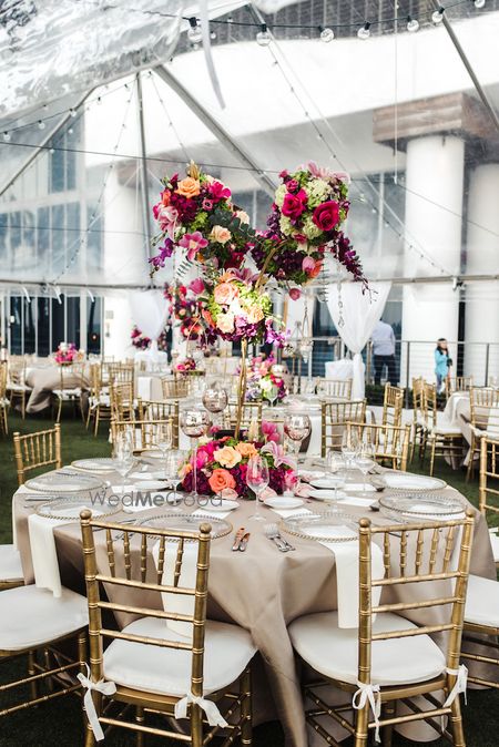 Photo of Gold table setting with giant floral centrepiece