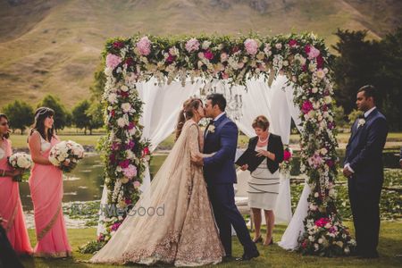 Photo of Bride and groom kiss at wedding