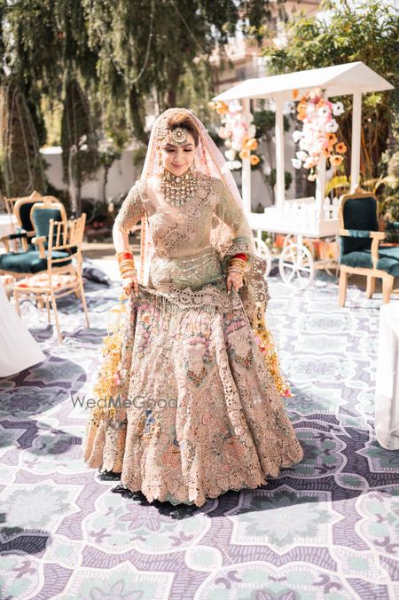 Photo of bride in pastel rimple and harpreet lehenga on her wedding day