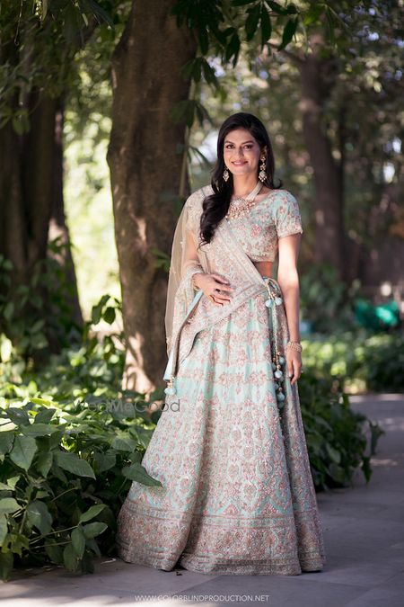 Photo of A bride poses in powder blue lehenga