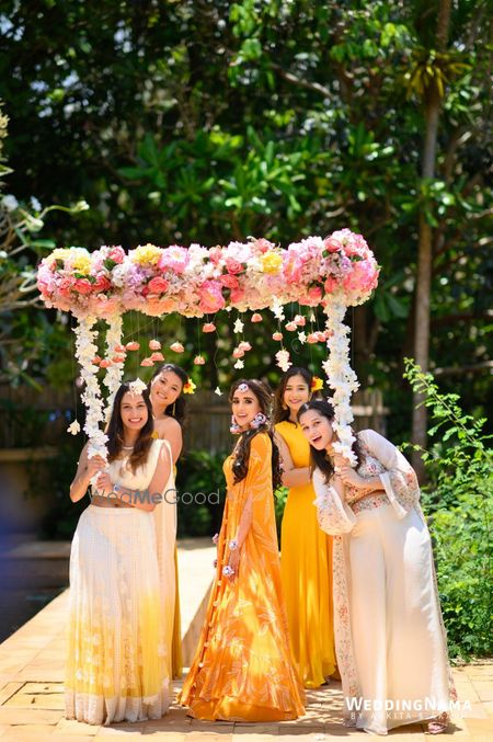 Photo of Bride making her entry with her bridesmaids under a beautiful phoolon ki chaadar.