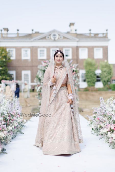 Photo of bride in light pink lehenga with white threadwork