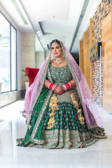 Photo of bride in a dark green anarkali with pink dupatta