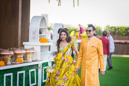 Photo of A bride and groom to be in yellow at their mehendi function