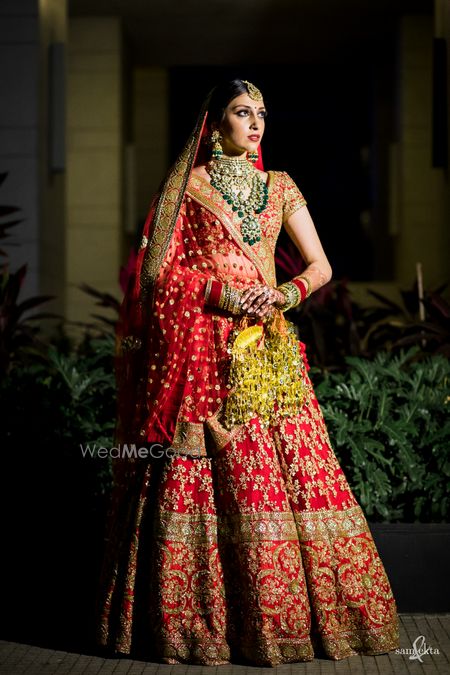 Photo of Pretty bridal portrait of a bride in red Sabyasachi lehenga