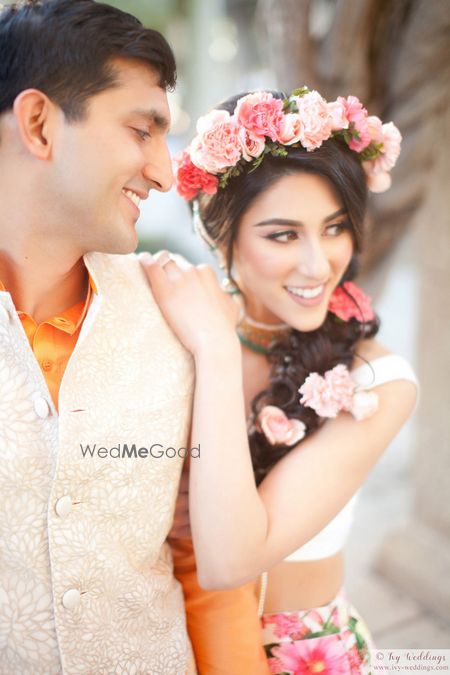 Photo of Pretty mehendi hairstyle with carnations in braid