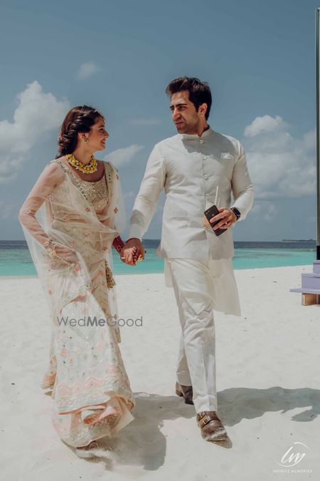 Photo of matching white bride and groom mehendi outfits