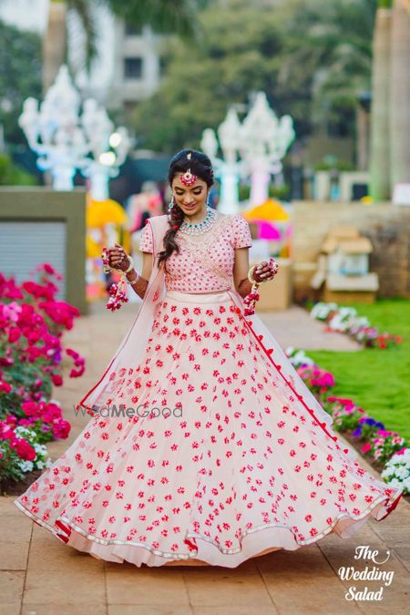 Photo of Bride showing off floral mehendi lehenga