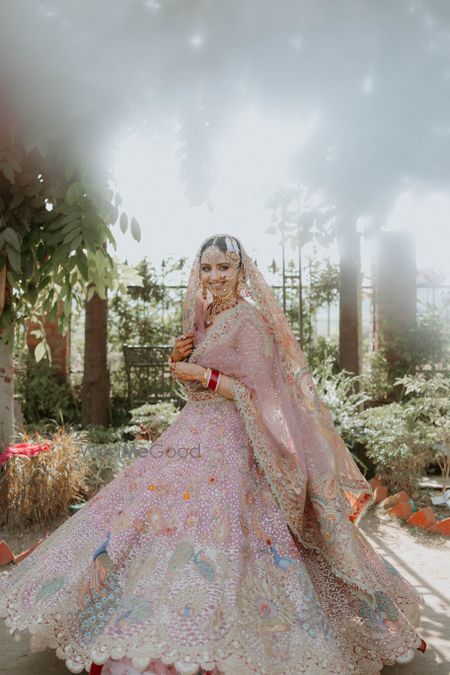 Photo of bride twirling in her wedding lehenga