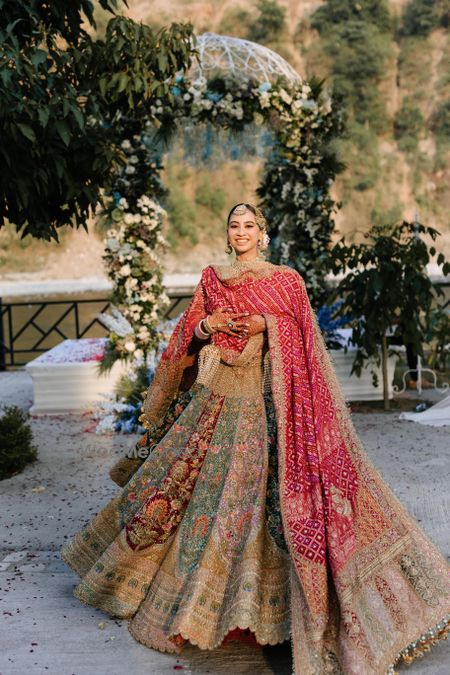 Photo of Stunning multi-coloured panelled bridal lehenga with an embroidered red dupatta