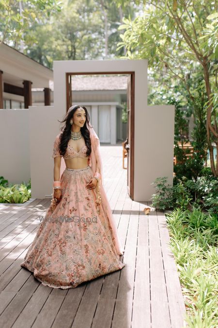 Photo of Lovely bridal portrait with bride in a peach pink pastel lehenga and baby pink chooda