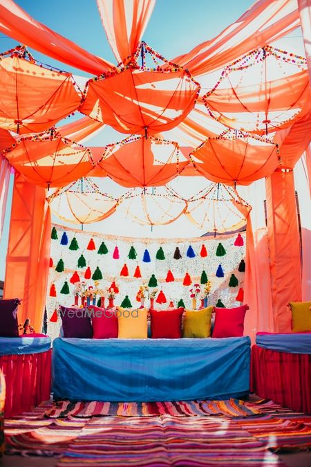 Photo of Colourful mehendi decor with tassels and hanging umbrellas