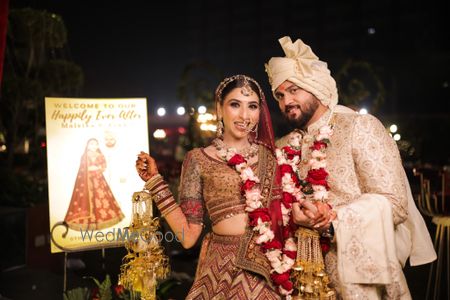 Photo of fun couple portrait with their wedding signage