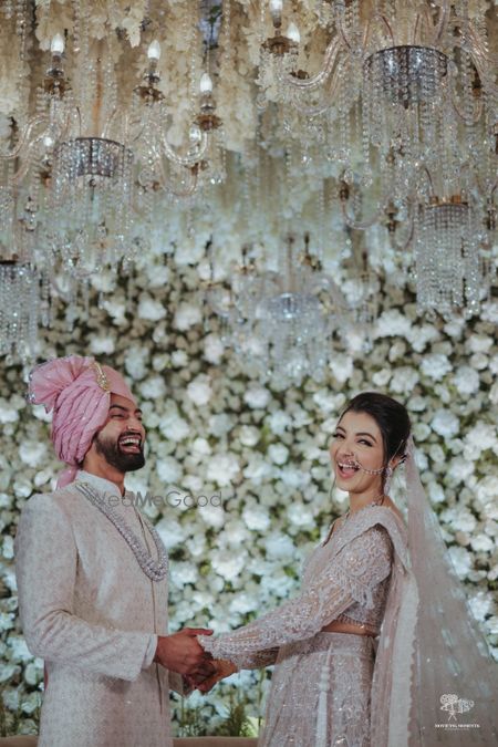 Photo of Happy couple shot against a floral wall backdrop