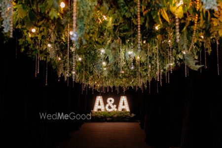 Photo of Fun giant LED letters in the couple's initials with hanging decor and lighting for the reception night