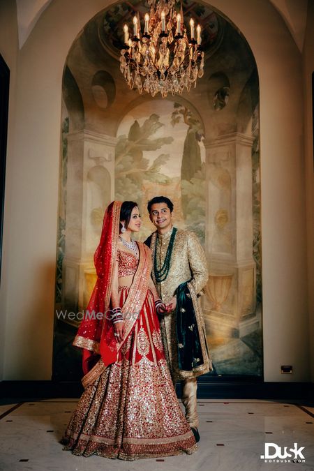 Photo of Red Sabyasachi bridal lehenga and groom