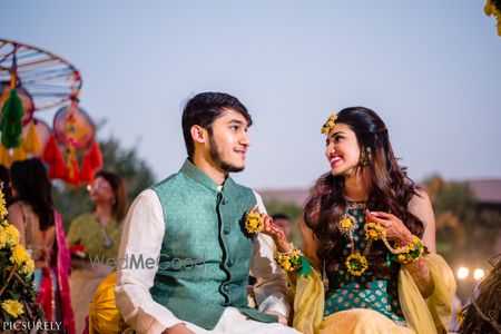 Photo of Matching bride and groom couple shot on mehendi wearing dark green