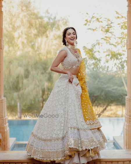 Photo of kiara advani on her mehendi in an ivory chikankari lehenga with yellow dupatta